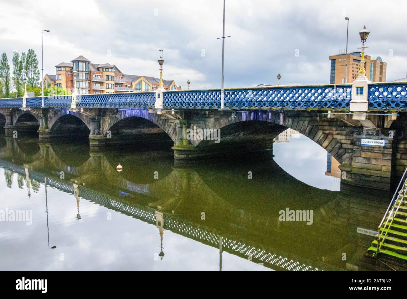Queen's Bridge over River Lagan in Belfast, Northern Ireland with bridge reflected in the water. Stock Photo