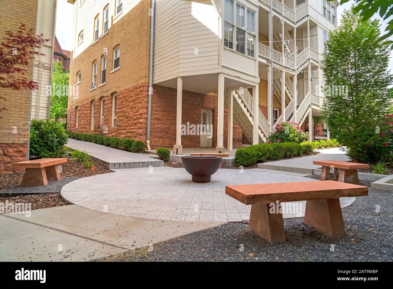 Fire Pit And Stone Benches Against Building With Stone Brick Wall