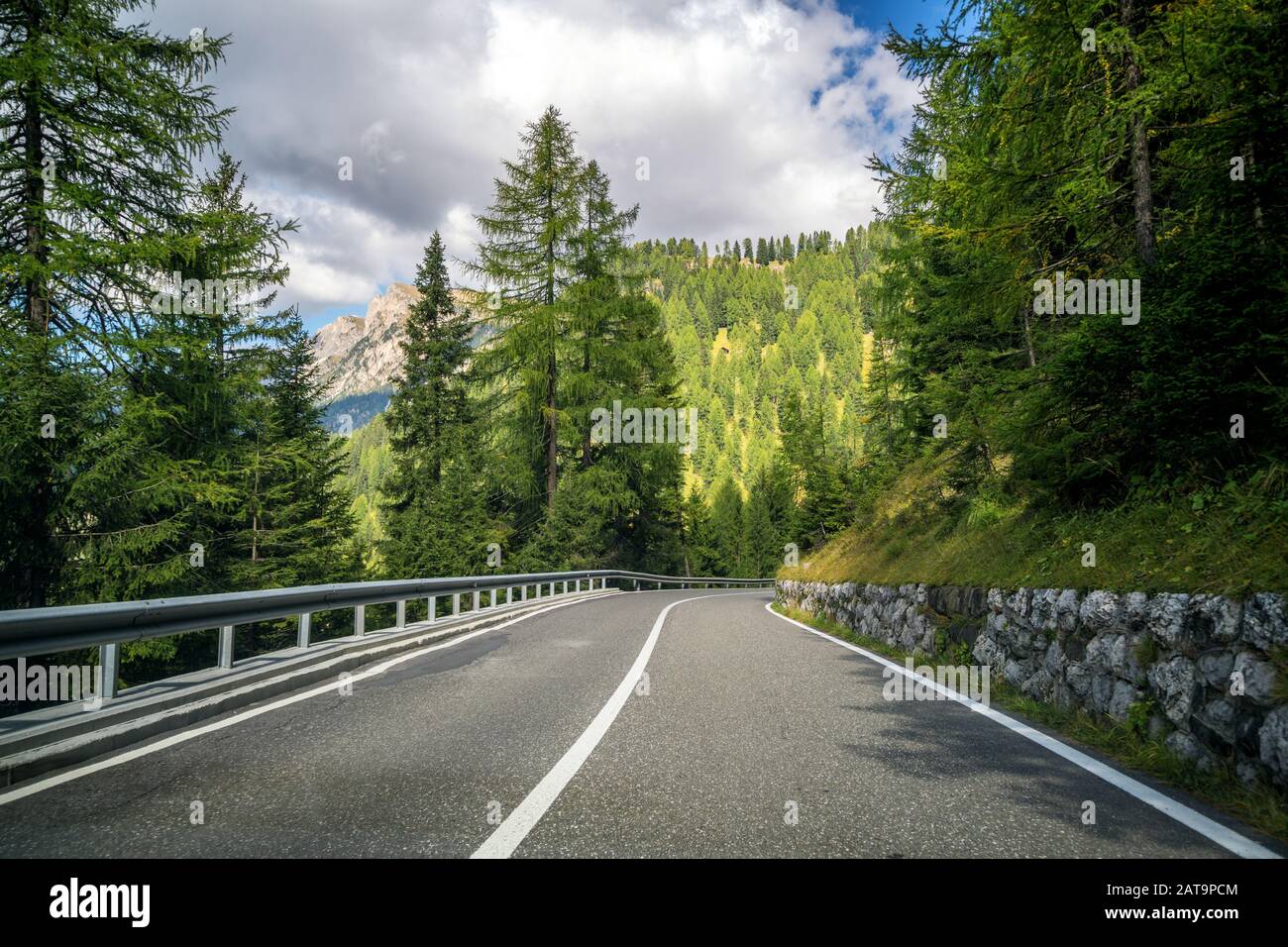Beautiful mountain road with trees, forest and mountains in the backgrounds.  Taken at state highway road of Dolomites mountain in Italy Stock Photo -  Alamy