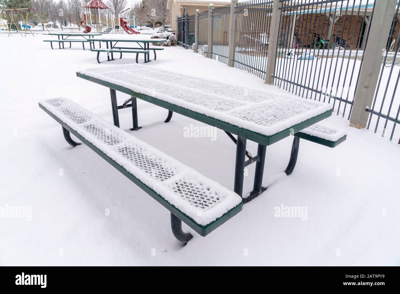 Park picnic table and benches against snow covered ground on a cold winter day Stock Photo