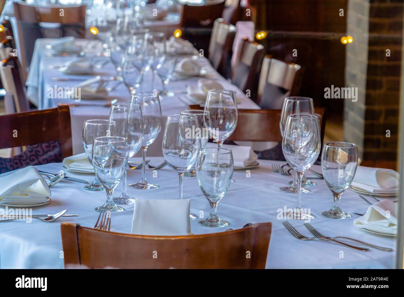 Tableware arranged on round table with white cloth for eating at an occasion Stock Photo