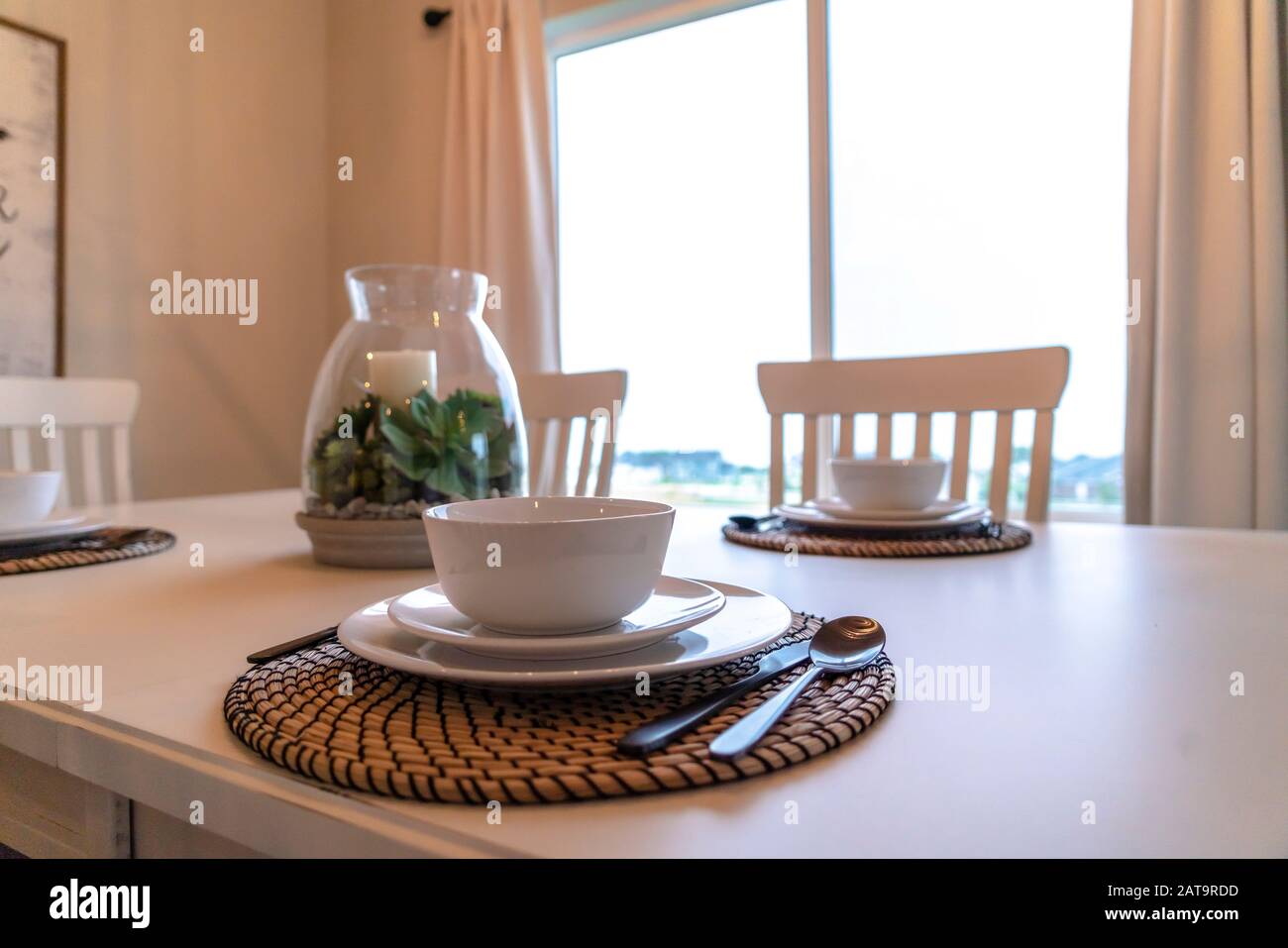 Soup bowl saucer and plate with spoon knife and fork arranged on a