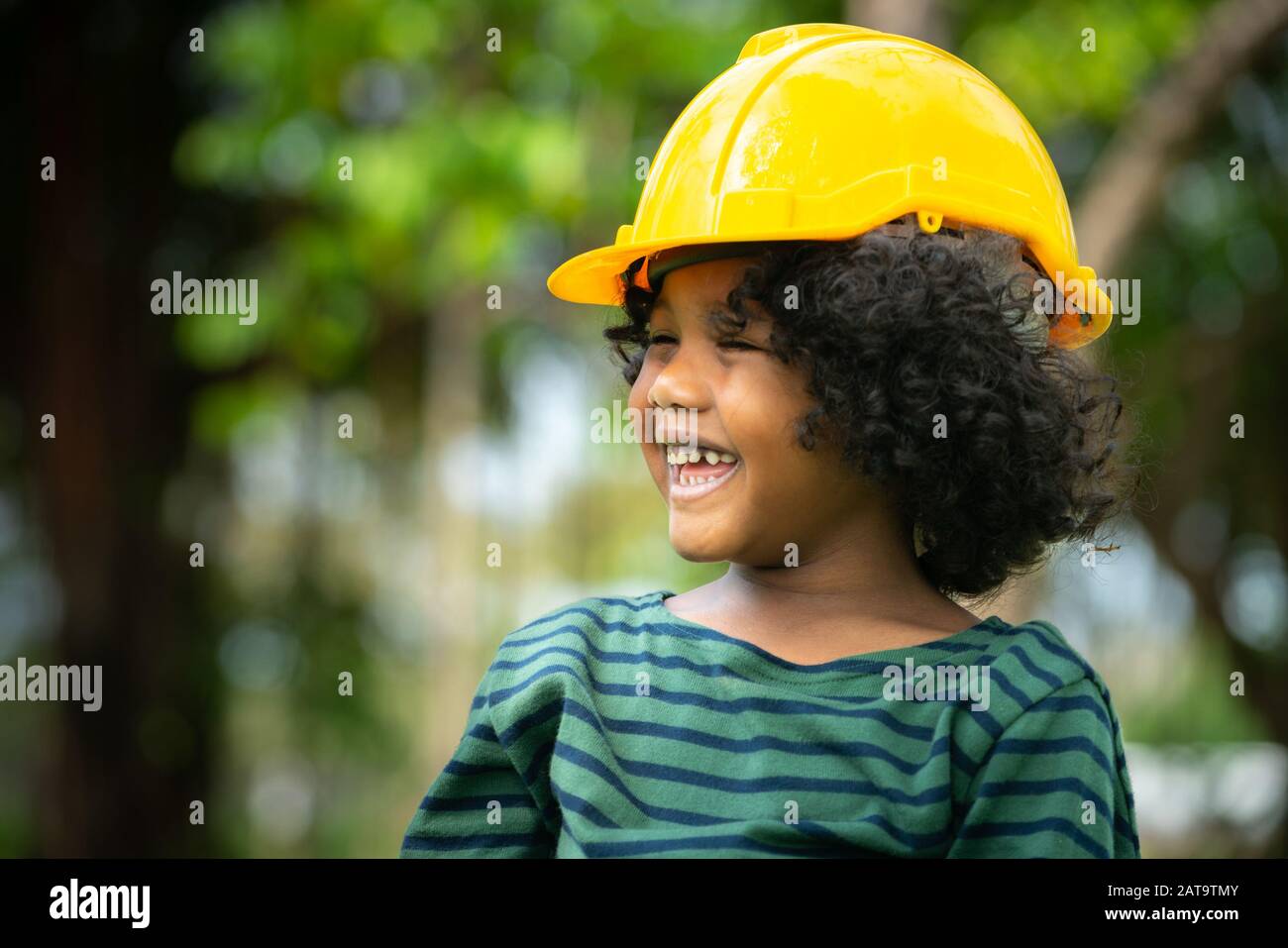 Happy little boy engineer wearing yellow safety helmet hard hat