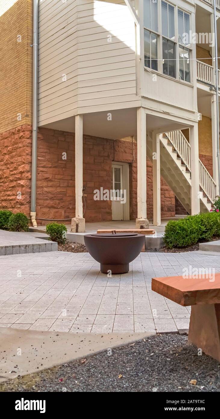 Vertical Frame Fire Pit And Stone Benches Against Building With