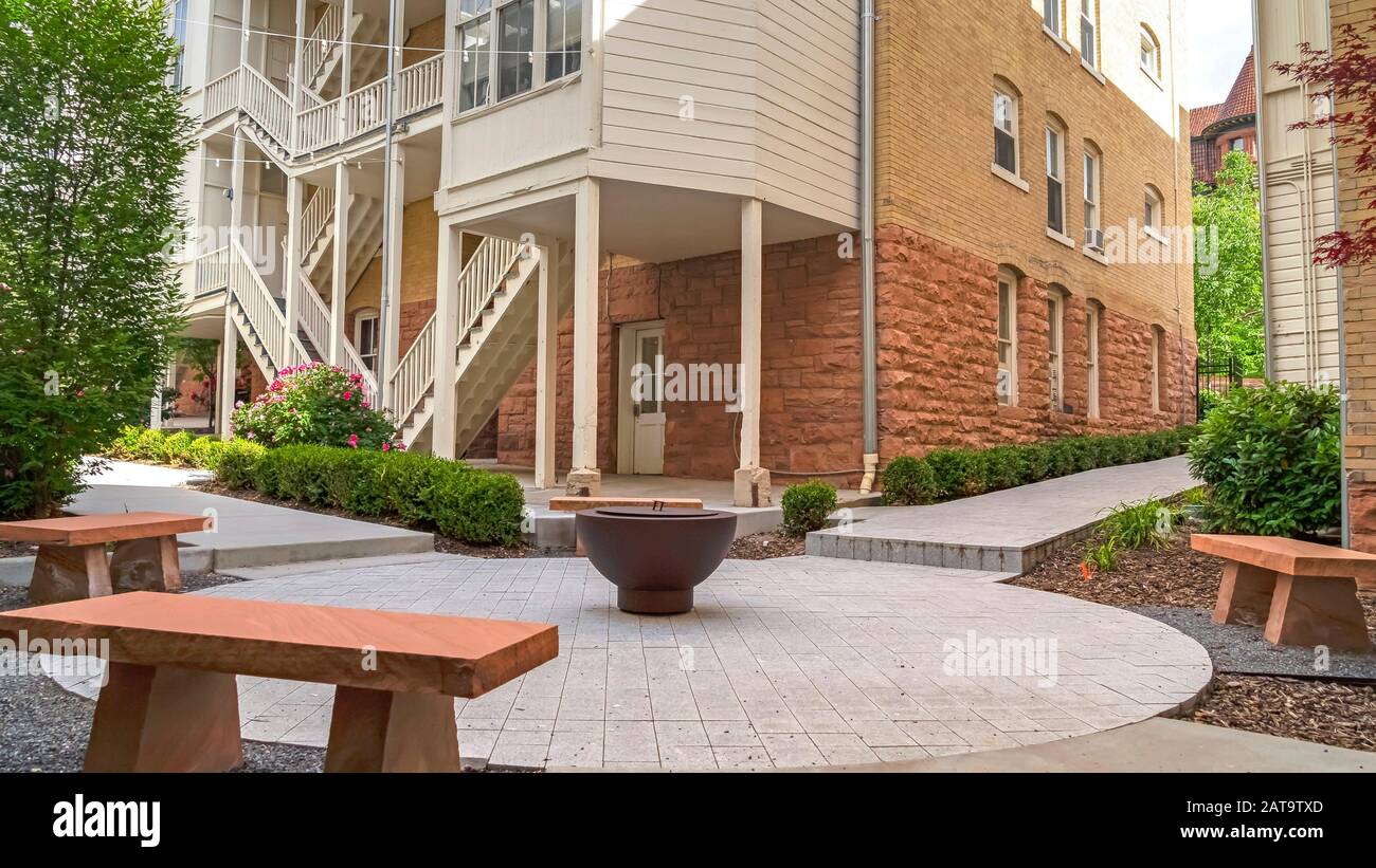 Panorama Fire Pit And Stone Benches Against Building With Stone