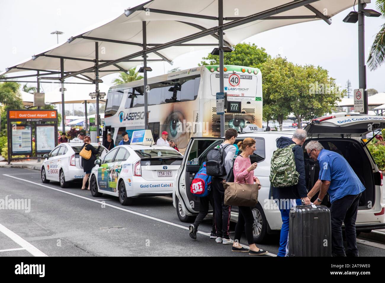 Gold Coast airport travellers at airport taxi rank where taxi driver helps load suitcases into the taxi,Queensland,Australia Stock Photo