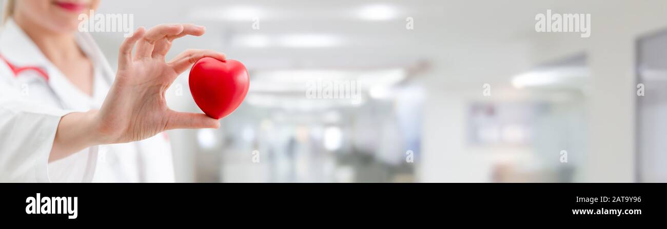 Doctor holding a red heart at hospital office. Medical health care and ...