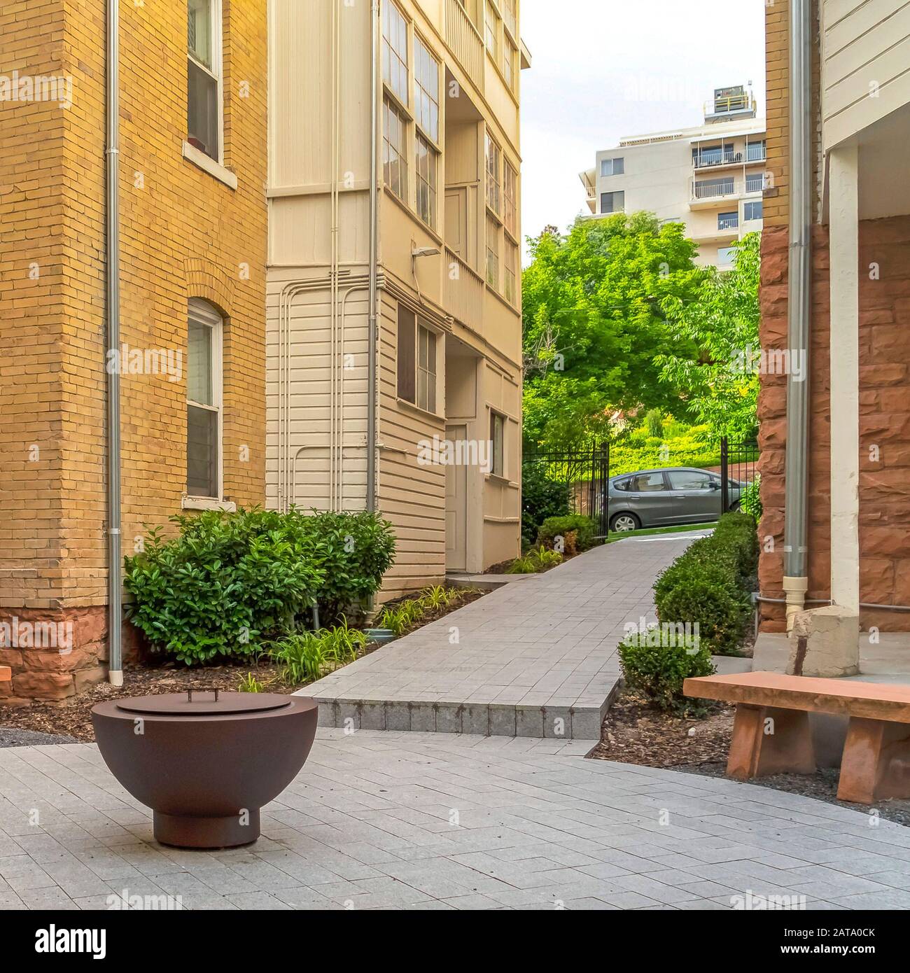 Square Frame Fire Pit On Circular Patio Outside Building With