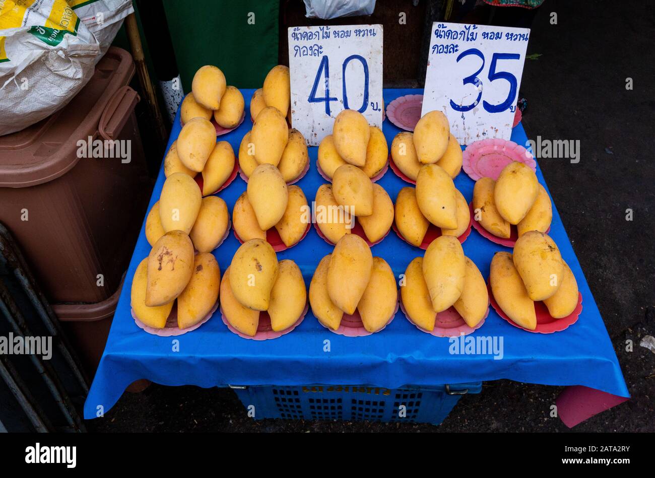 Yellow mangoes for sale at an open-air street market in Chiang Mai, Thailand, with prices in Baht (Thailand currency). Stock Photo