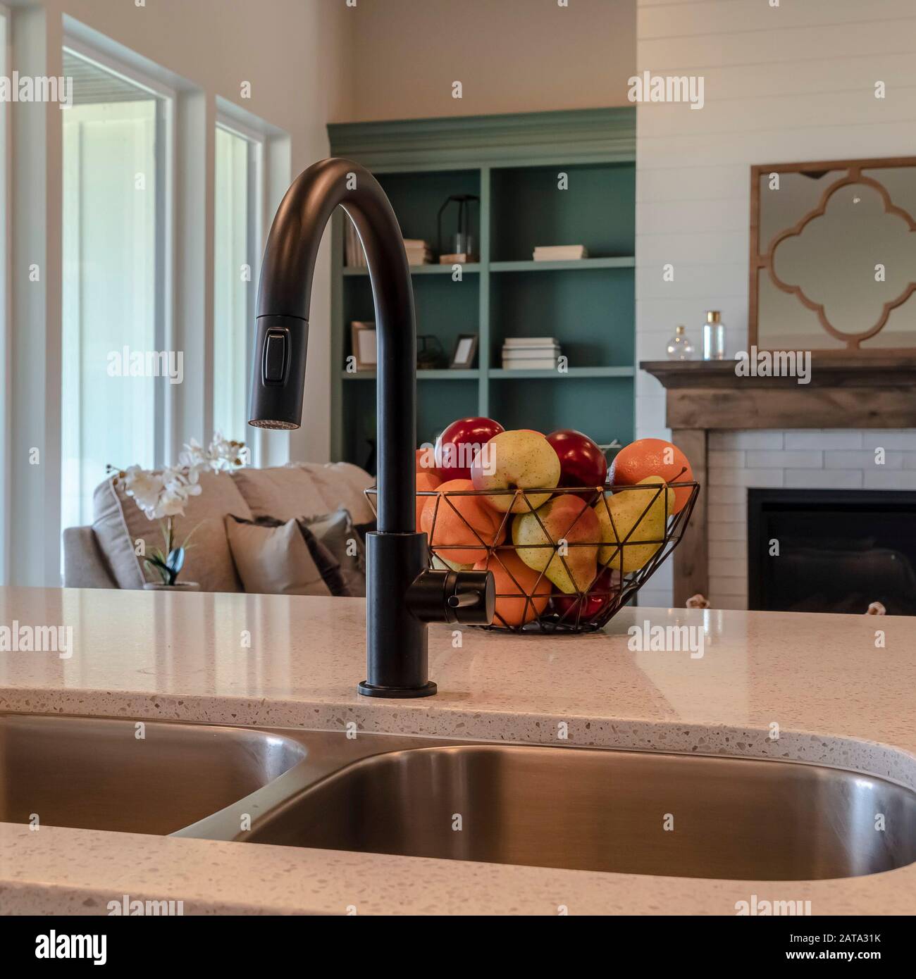 Photo Square Kitchen Island Sink With Black Faucet Fruit Basket And Double Basin Sink Stock Photo Alamy