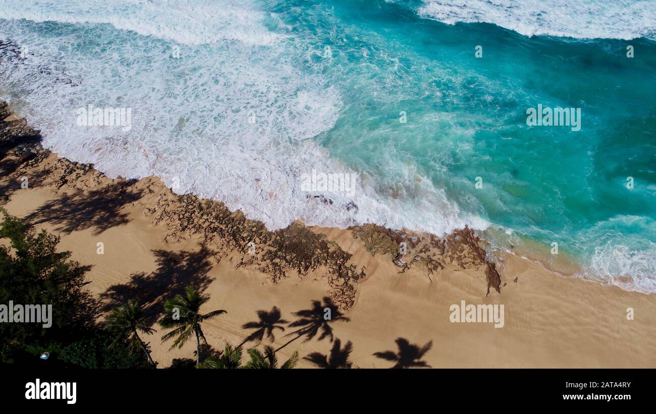 Aerial view of bright blue water and surf with waves crashing at Bonzai