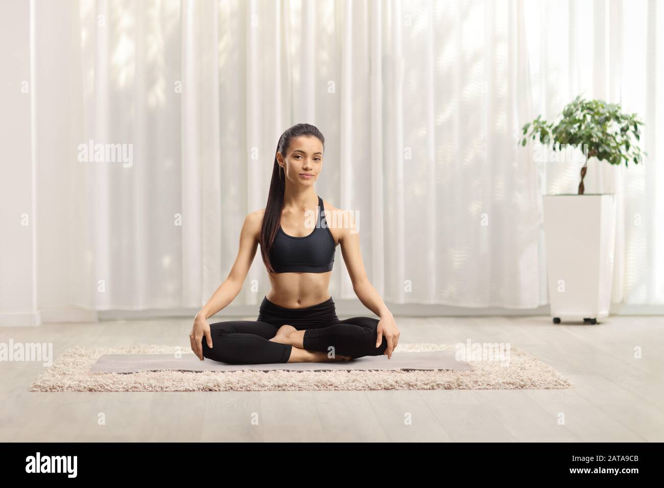 Young beautiful woman exercising yoga at home Stock Photo