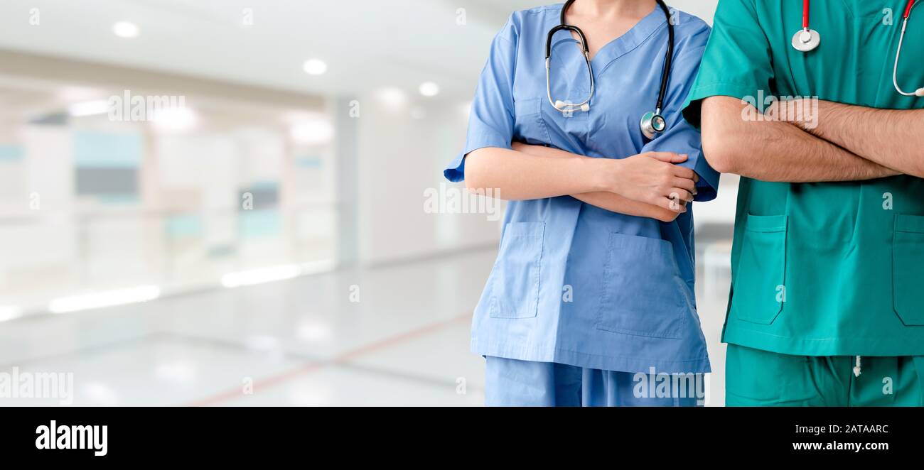 Two hospital staffs - surgeon, doctor or nurse standing with arms crossed in the hospital. Medical healthcare and doctor service. Stock Photo