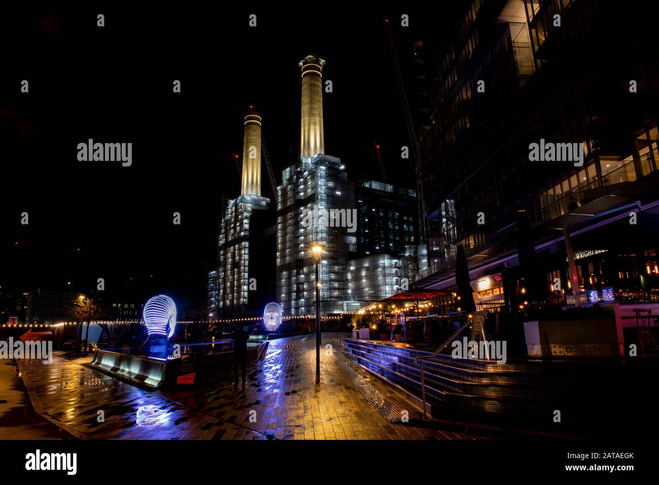 A view of two heads made up of lights entitled 'Talking Heads' by Victor Vicsek at West Circus Village at Battersea Power Station in London Stock Photo