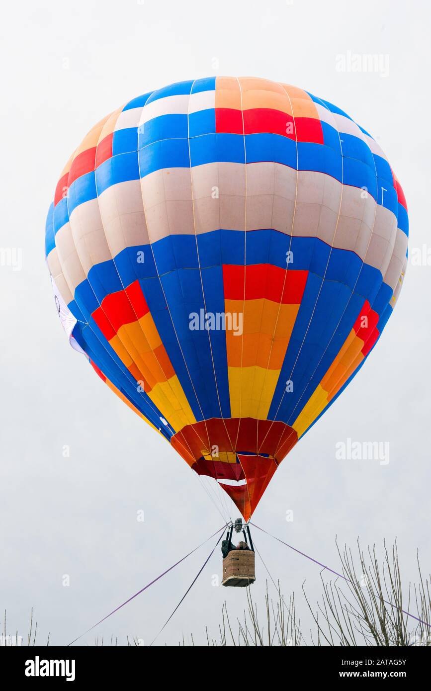 passengers into hot air balloon basket above trees, ready for launch, White background Stock