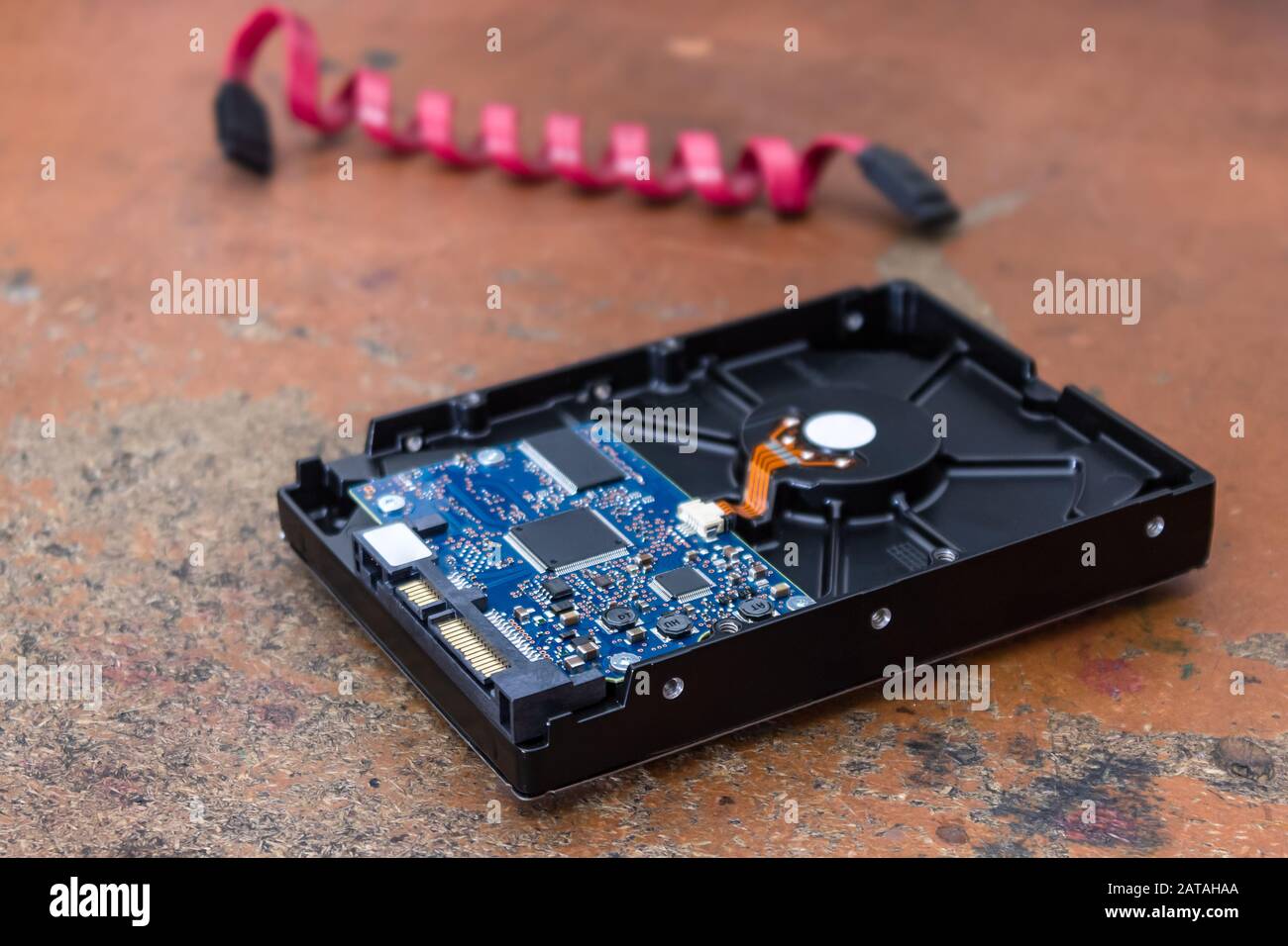 Computer hard drive lies on a table in an electronics repair shop Stock Photo