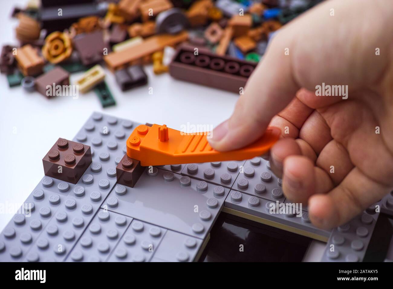 Tambov, Russian Federation - January 02, 2020 Child removing misplaced Lego brick with brick separator. Studio shot. Stock Photo