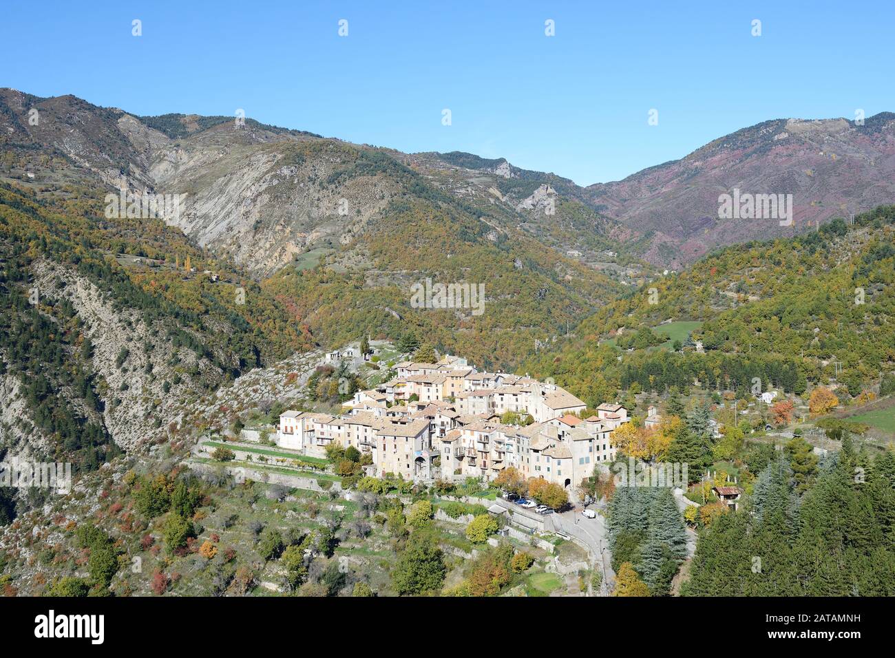 AERIAL VIEW. Picturesque isolated hilltop village in the fall. La Croix-sur-Roudoule, French Riviera's backcountry, France. Stock Photo