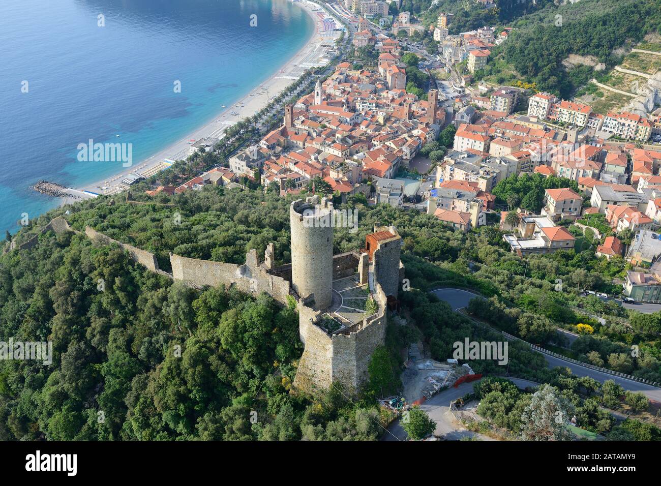 AERIAL VIEW. Castle overlooking the medieval village of Noli. Province of Savona, Liguria, Italy. Stock Photo