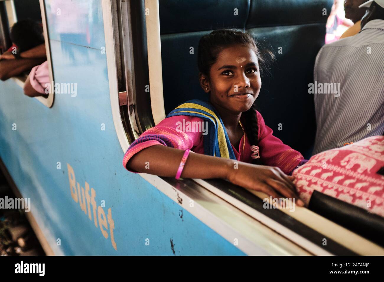 A young girl sitting on a train in Sri lanka and smilig. Stock Photo