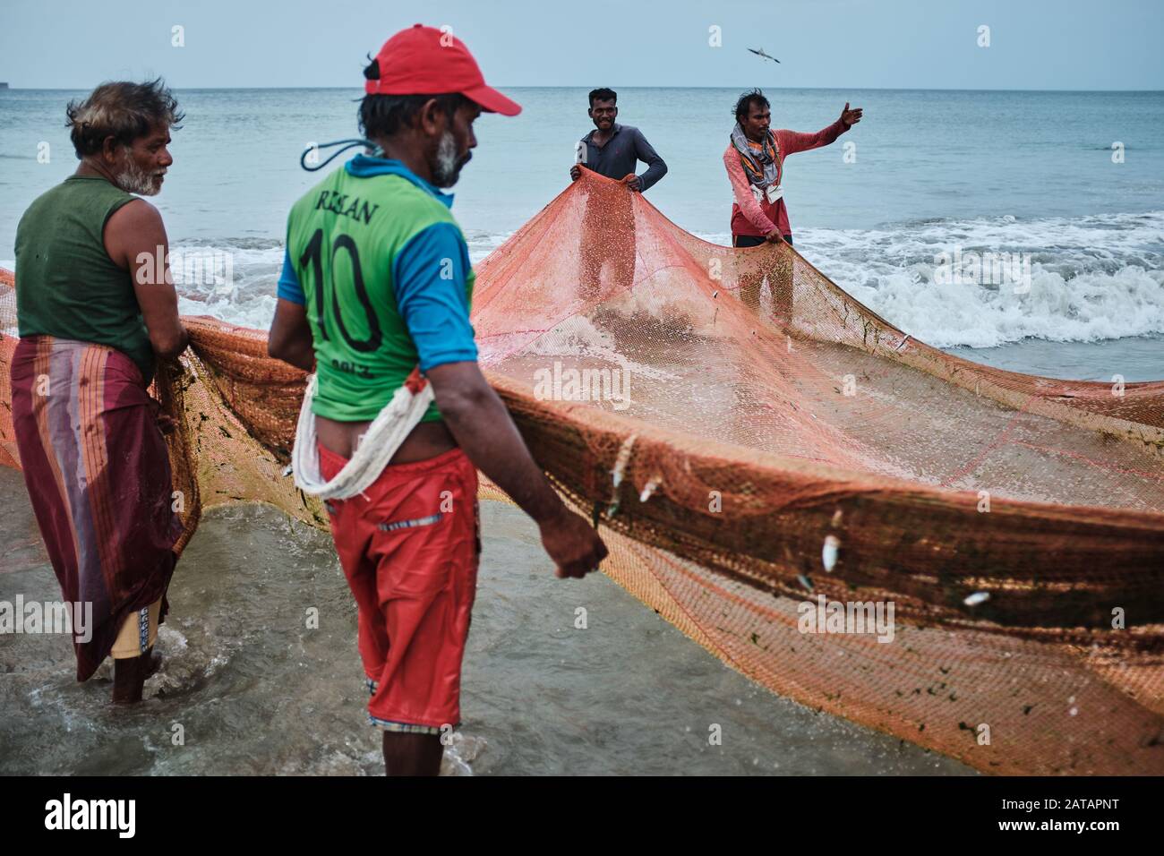 Fishermen pulling the nets out of the ocean on the beach in Sri
