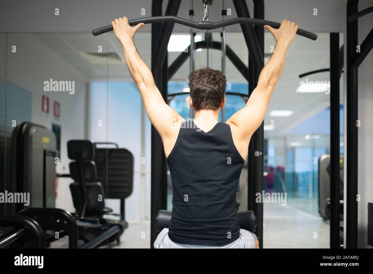 Man using a lat machine in a gym to train his shoulders and back bodybuilding and natural fitness concept Stock Photo Alamy
