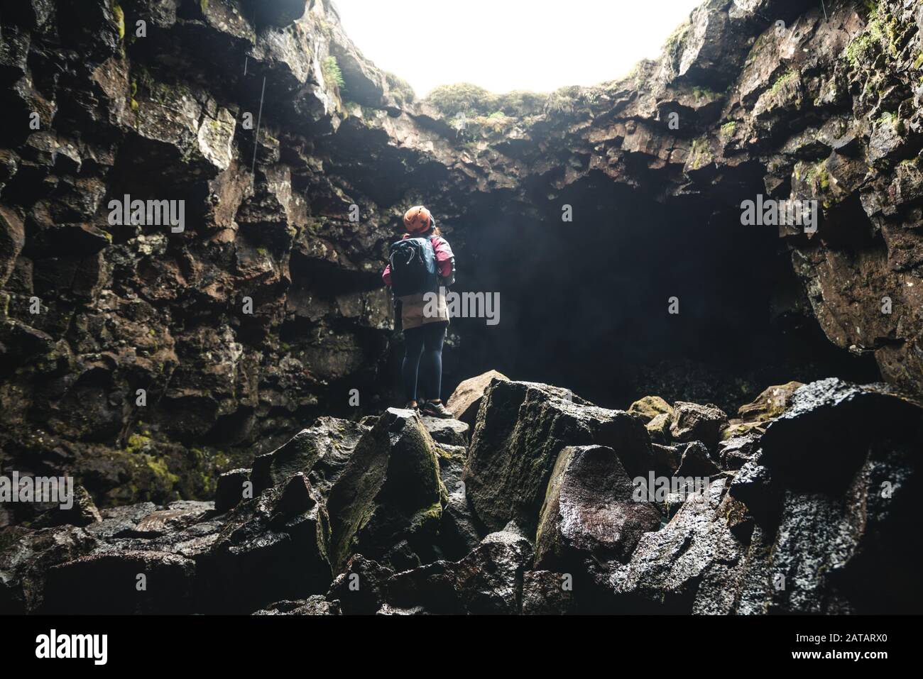 Woman traveler explore lava tunnel in Iceland. Raufarholshellir is a