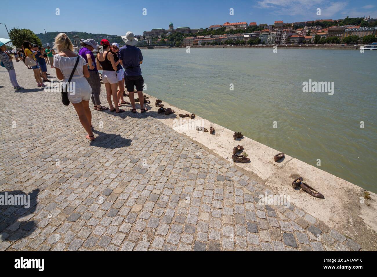 Budapest, Hungary – Tourists and  Shoes on the Danube Bank Holocaust Memorial, landscape on July  2 2019 in Hungary. Stock Photo