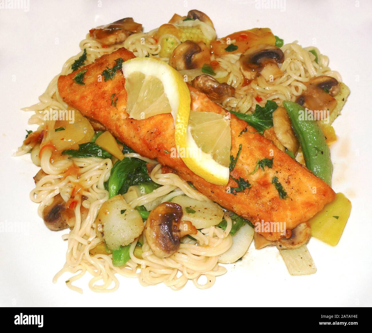 Fried Thai salmon with noodles and stirfried vegetables Stock Photo