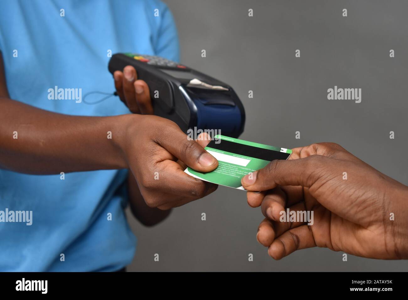 african lady holding a mobile point of sale machine collecting a credit card for someone Stock Photo