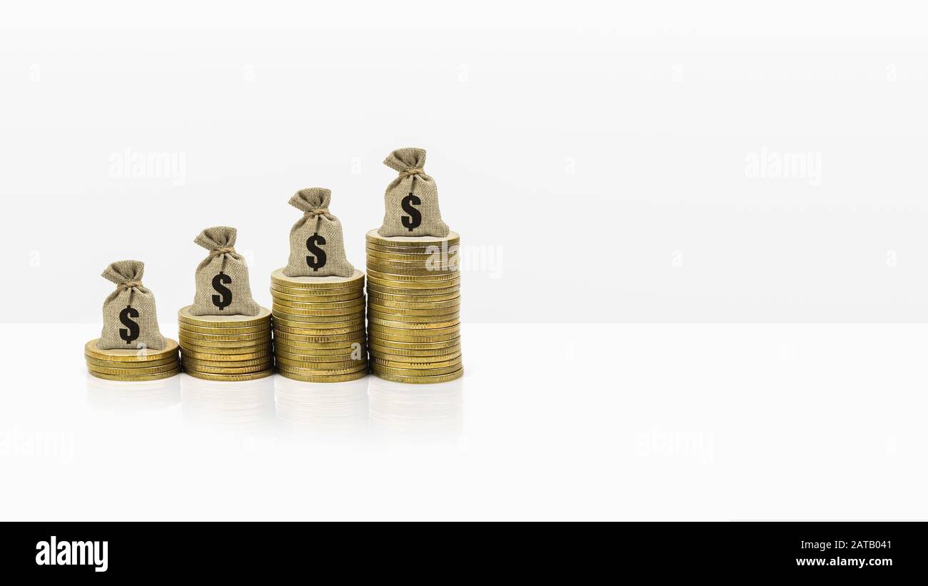 Money savings and investment banner concept. Money bag on rise stacked of coins on white background and space. Demonstrating long-term lasting wealth Stock Photo