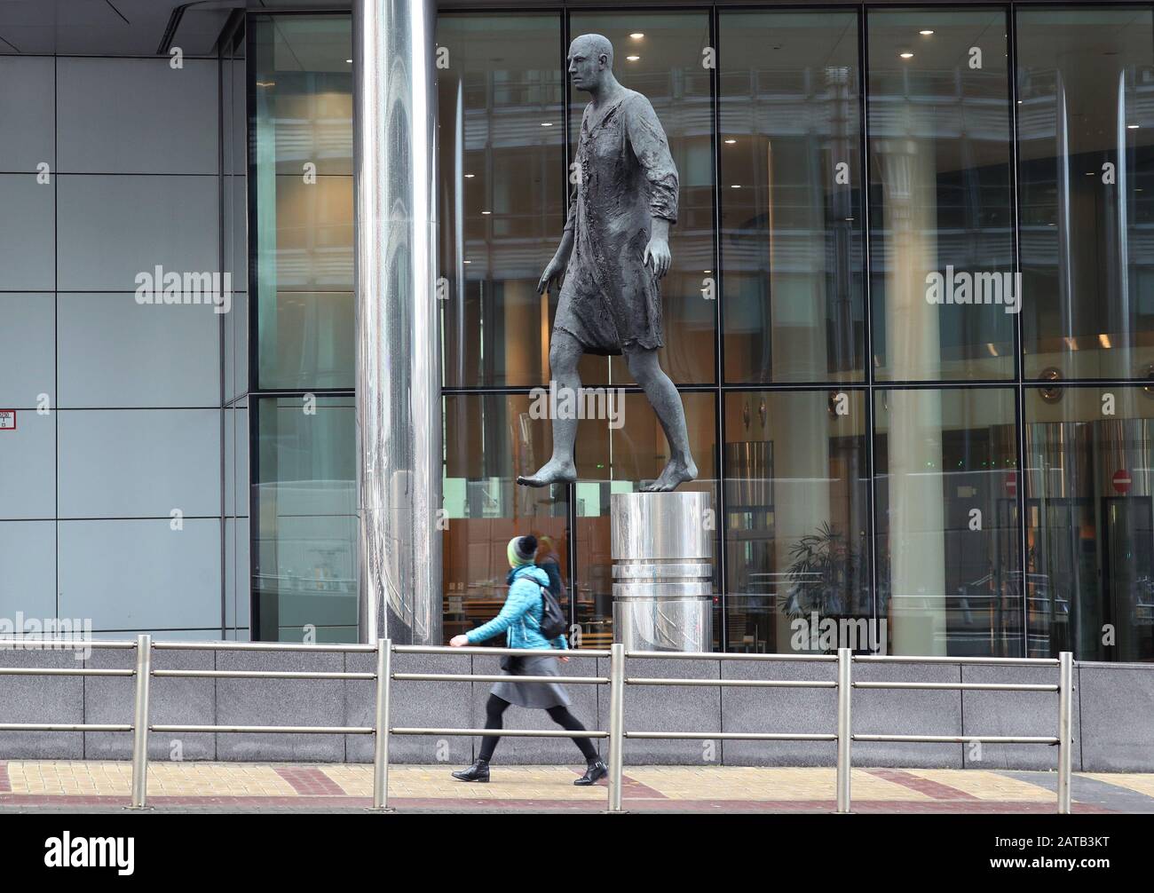 A woman walking past the sculpture Stepping Forward (2007), by Hanneke Beaumont, on the morning after Brexit, in Brussels, Belgium. Stock Photo