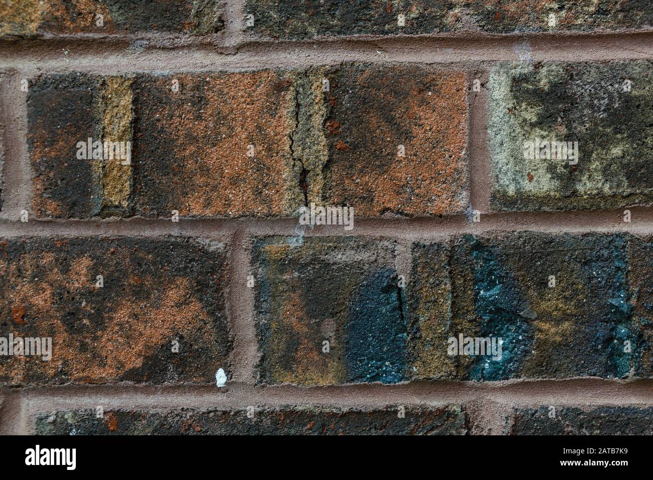 Weathered, multi-colored brick wall closeup, background Stock Photo