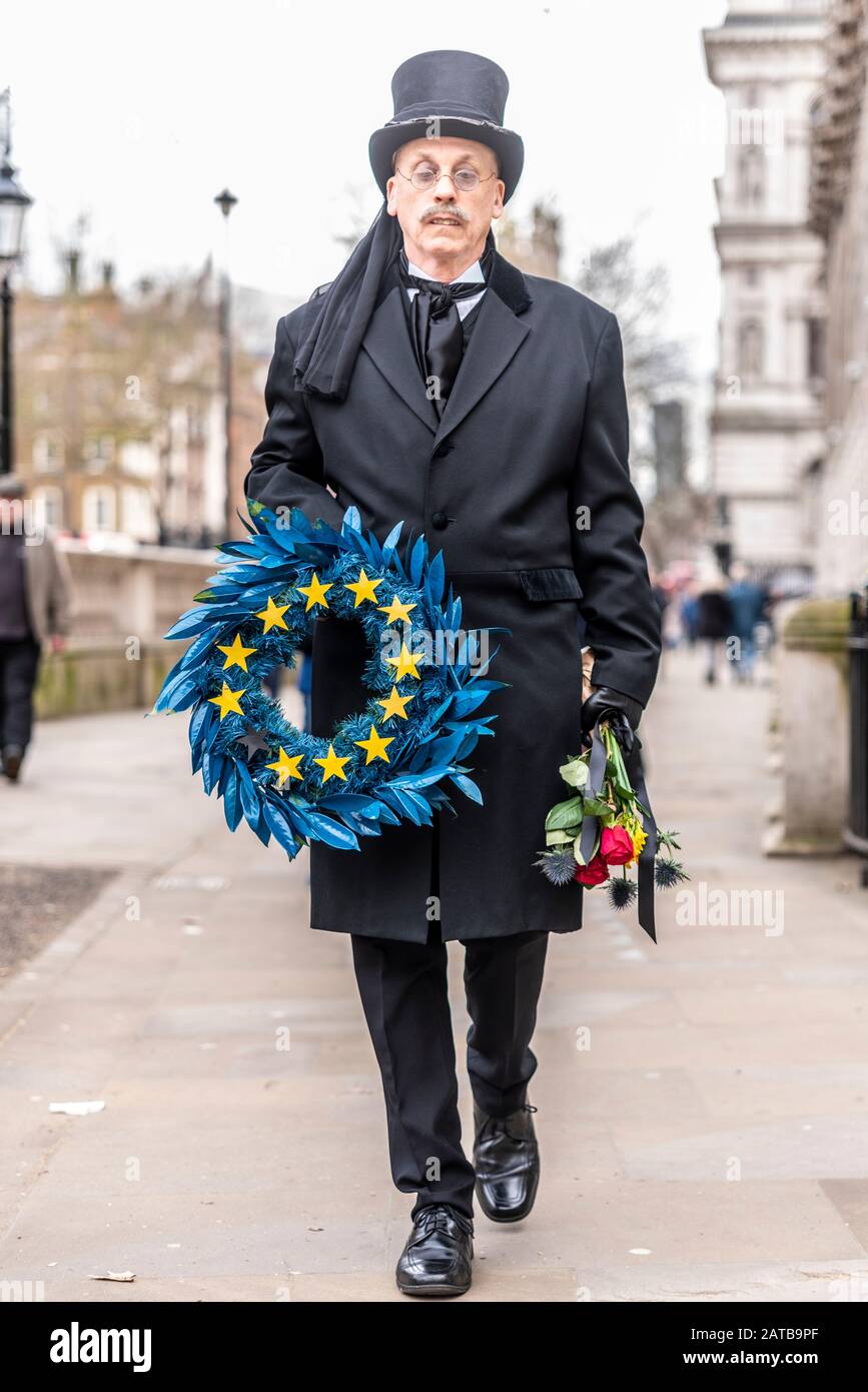 White male in funeral attire carrying a wreath in European Union flag colours mourning exit from EU on Brexit Day, 31 January 2020, in London, UK Stock Photo