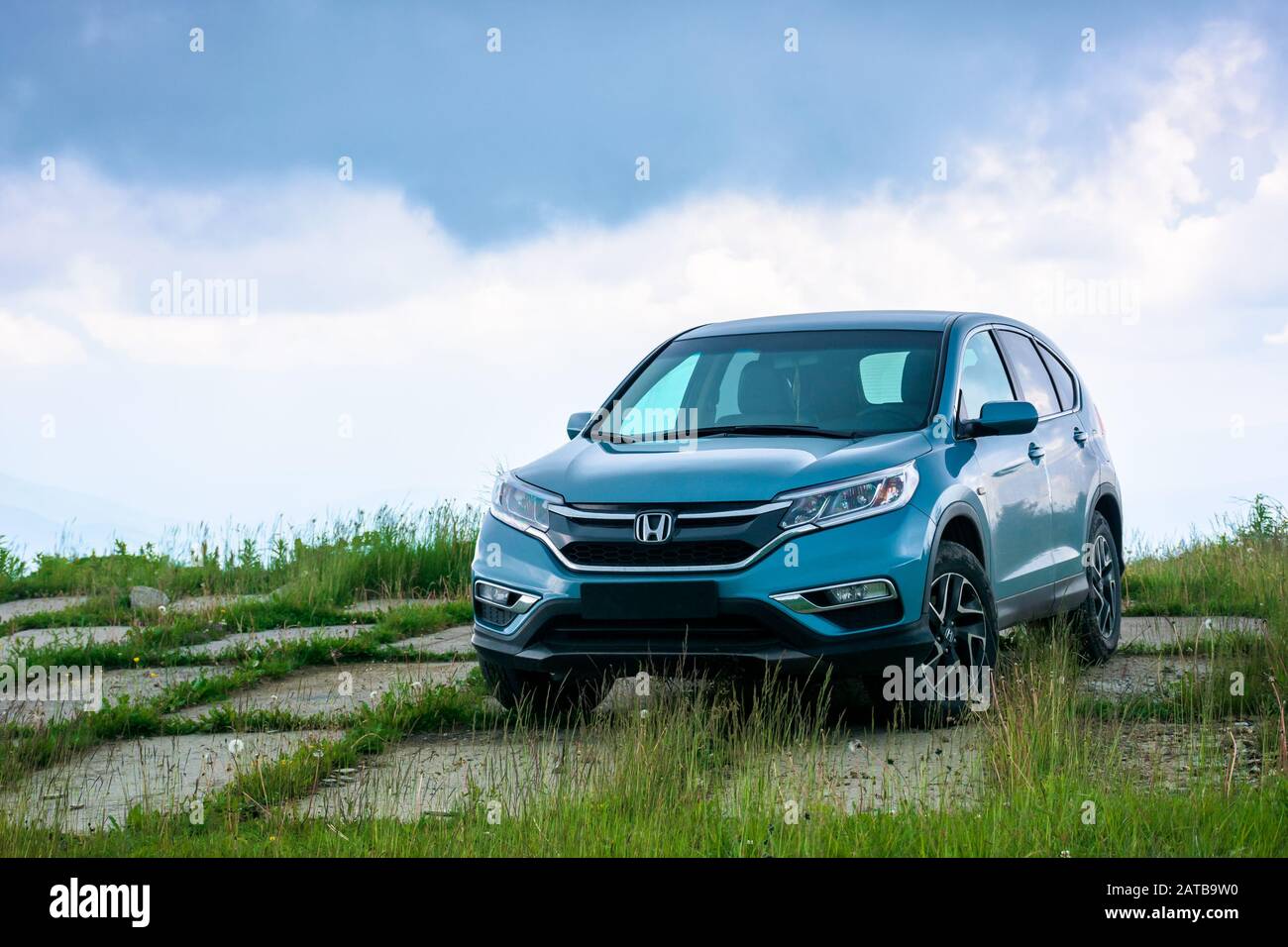 mnt. runa, ukraine - JUN 22, 2019: blue suv on a paved meadow. popular AWD vehicle in nature scenery. stormy weather with cloudy sky. take your family Stock Photo
