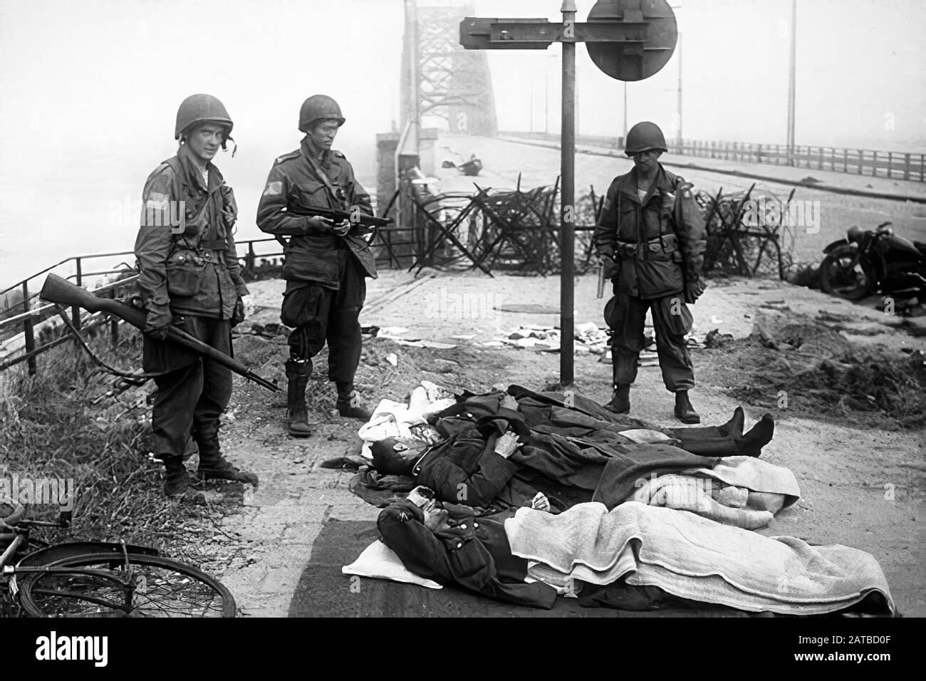 U.S. 82nd Airborne paratroopers guard wounded German soldiers at the Waalbrug, Nijmegen, 1944 Stock Photo
