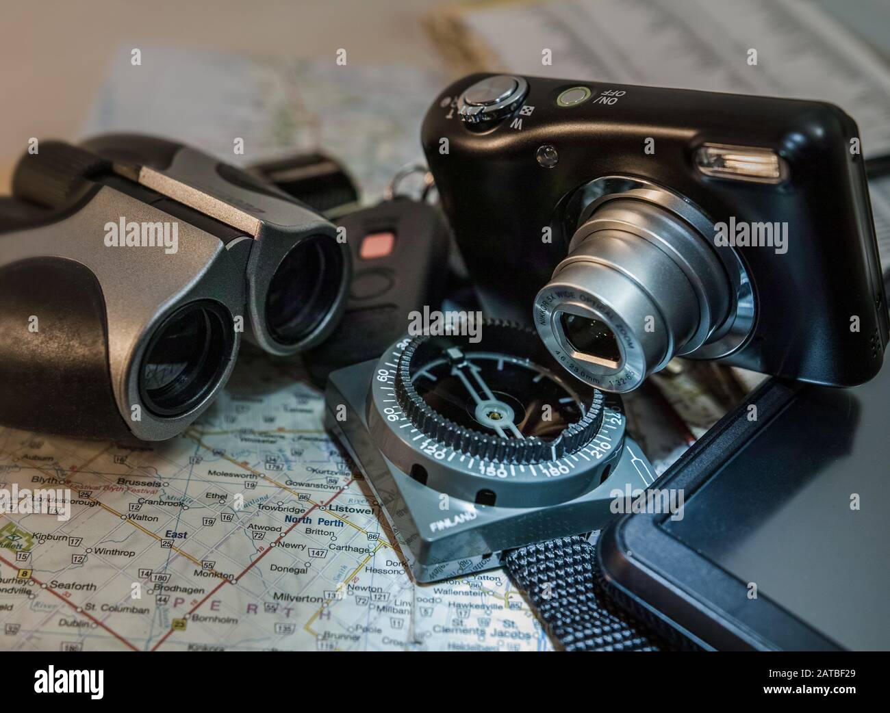 On a map you see binoculars, compass, camera and GPS Stock Photo - Alamy
