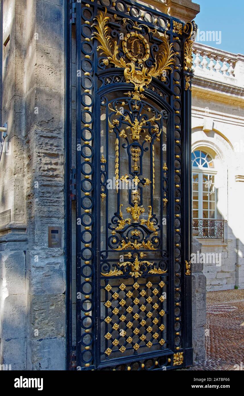 ornate iron gate, black, gold, entrance, Calvet Museum, courtyard, 18 century mansion, art, old stone building, sun, shade, Provence, Avignon, France, Stock Photo