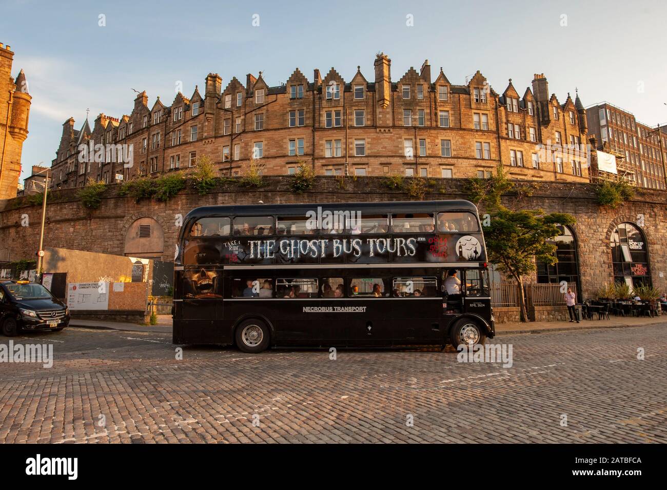 East market street of Edinburgh at sunset. The ghost tours bus. Edinburgh cityscape/travel photograph by Pep Masip. Stock Photo