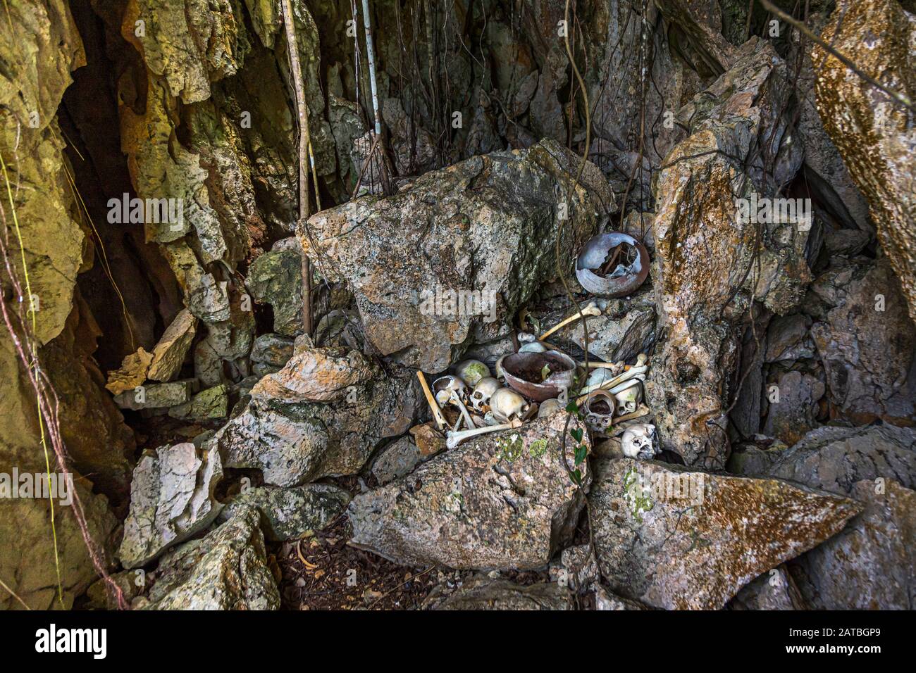 Skulls of cannibals left behind in a cave on the island of Pana Wara Wara in Papua New Guinea. Skulls and human bones are clearly visible at the cannibal cult site Stock Photo