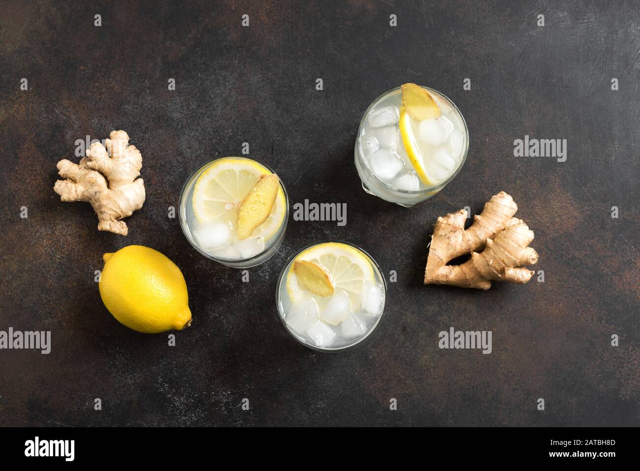 Ginger Ale Cocktail or Ginger Beer with lemon and ice on rustic