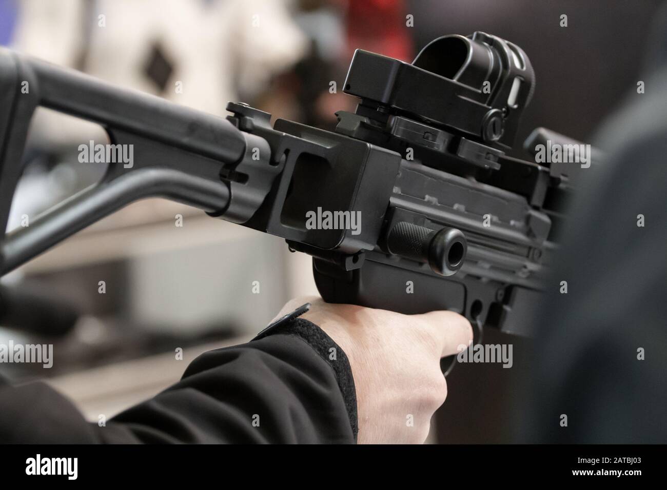 Mens choose guns on stands with weapons. Weapon stand at an arms