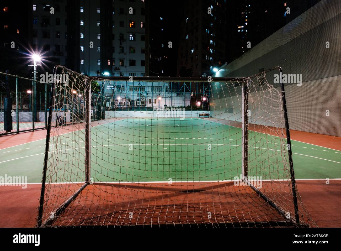 soccer goal on sports field in city at night - Stock Photo