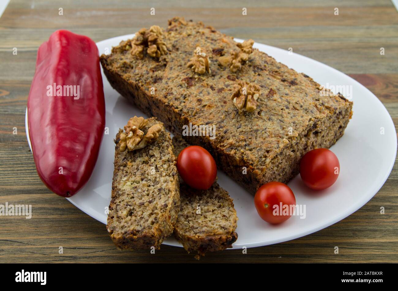 Healthy seed bread on a plate with vegetables, keto, ketogenic diet, paleo, low carbohydrate. Lifestyle change and effective weight reduction. Stock Photo