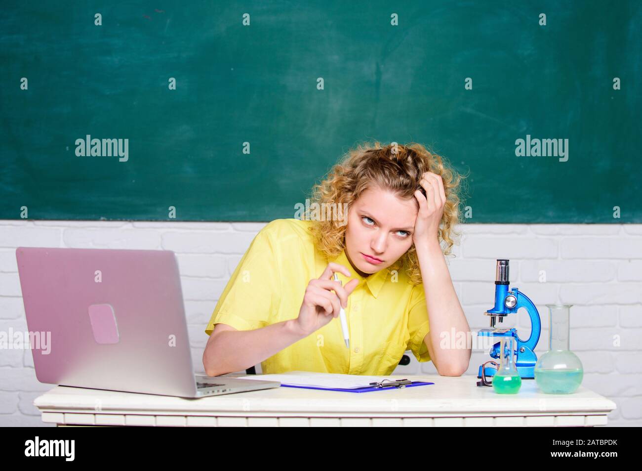 make notes about chemistry research results. girl in classroom ...