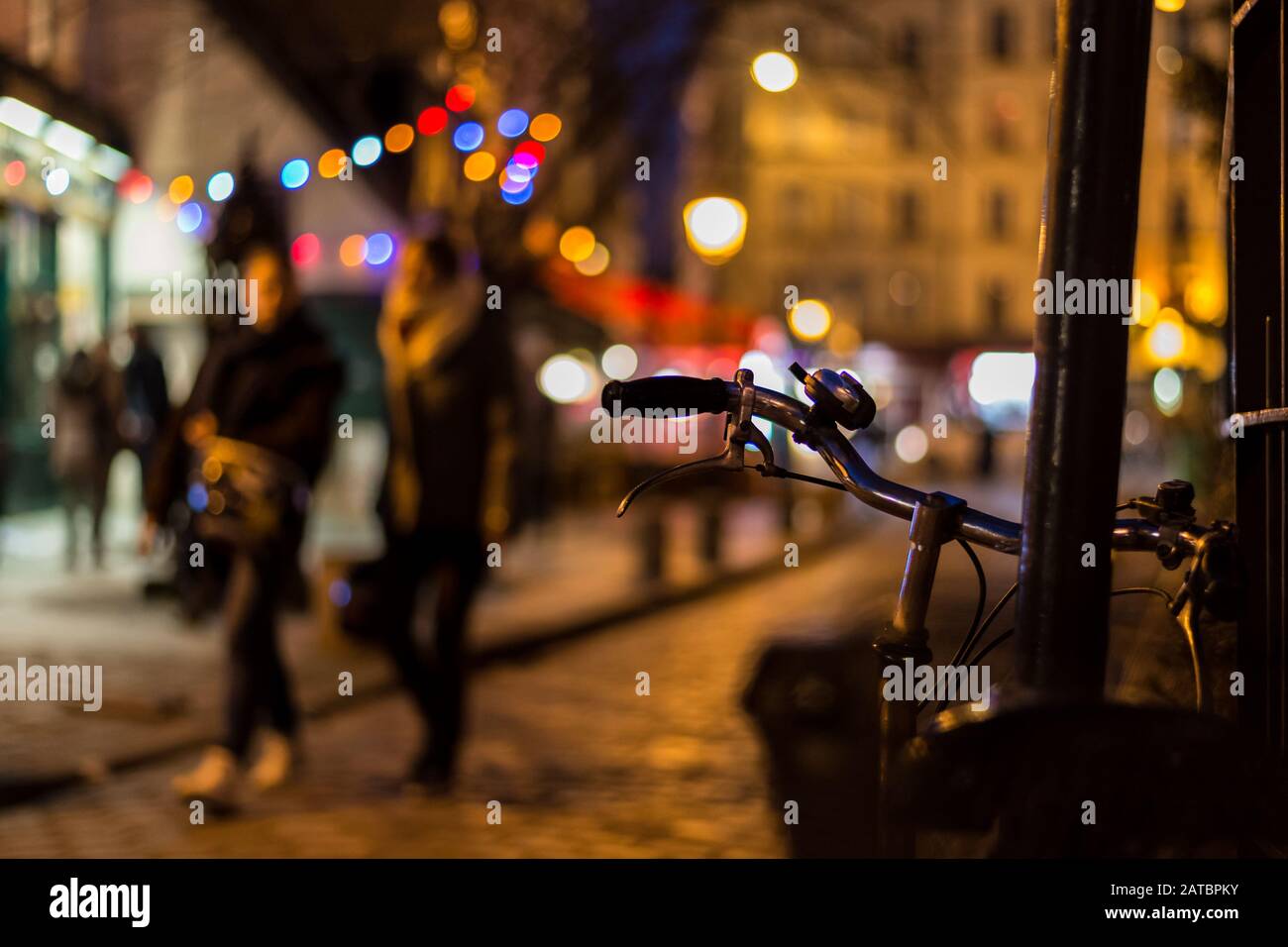 Romantic Scene Of People Wandering Through The Illuminated Cobbled Streets Of Paris At Night Stock Photo Alamy
