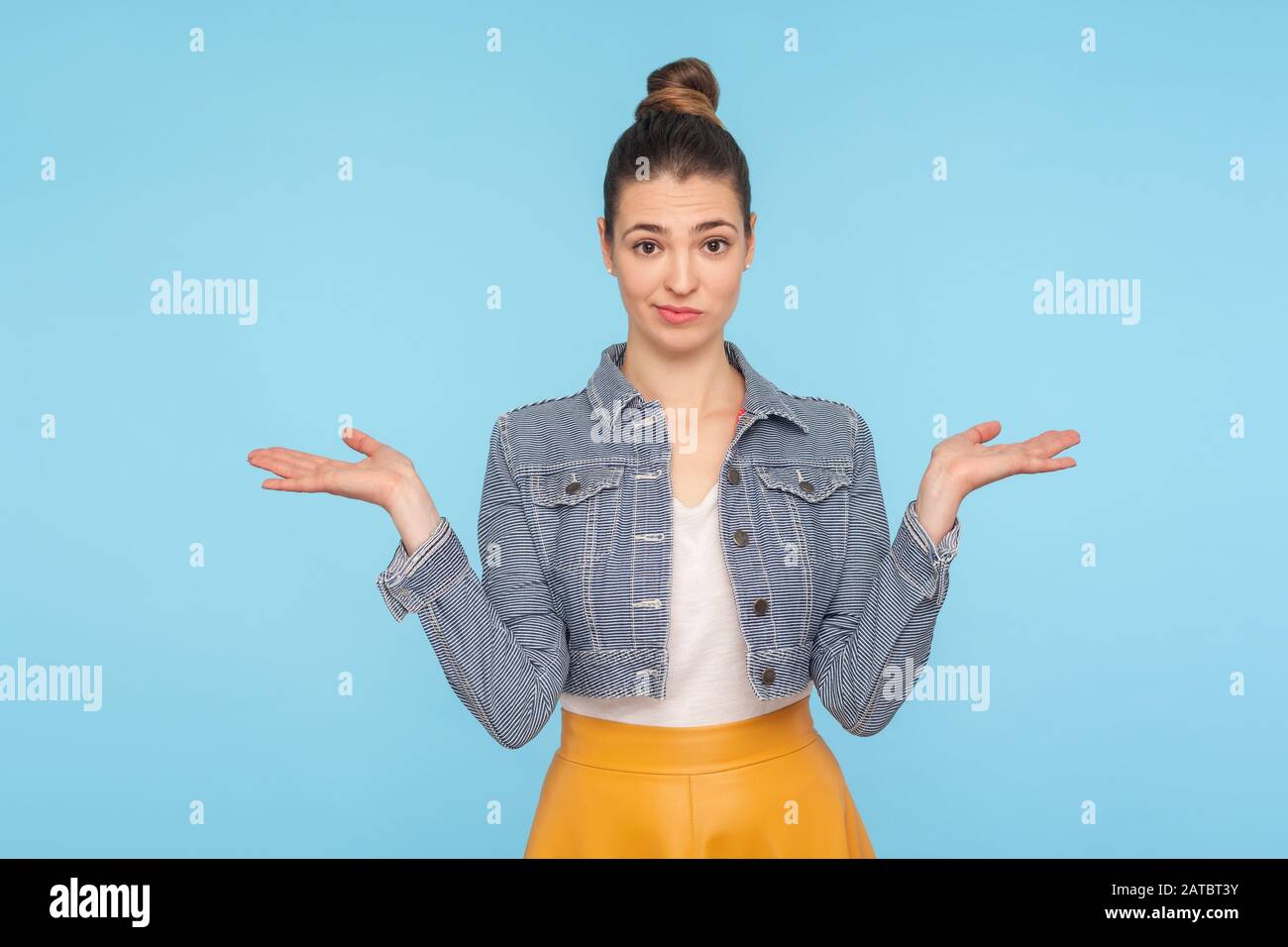 I don't know, who cares. Portrait of confused clueless uncertain woman with hair bun in fashionable clothes shrugging shoulders with careless indiffer Stock Photo