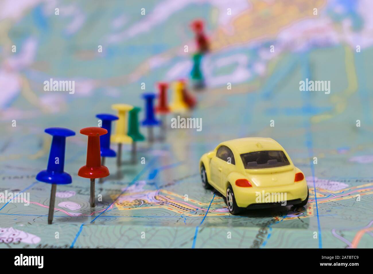Dnepr, Ukraine - January  17, 2018:  The toy car moves around the world map, according to the marked drawing pin route. Selective focus Stock Photo