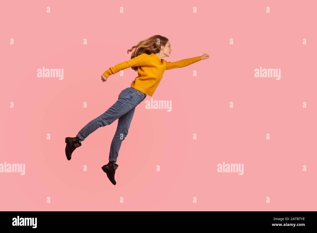 Superpower. Portrait of determined serious ginger girl in sweater and denim flying in air forward to victories, superhero feeling free and confident t Stock Photo