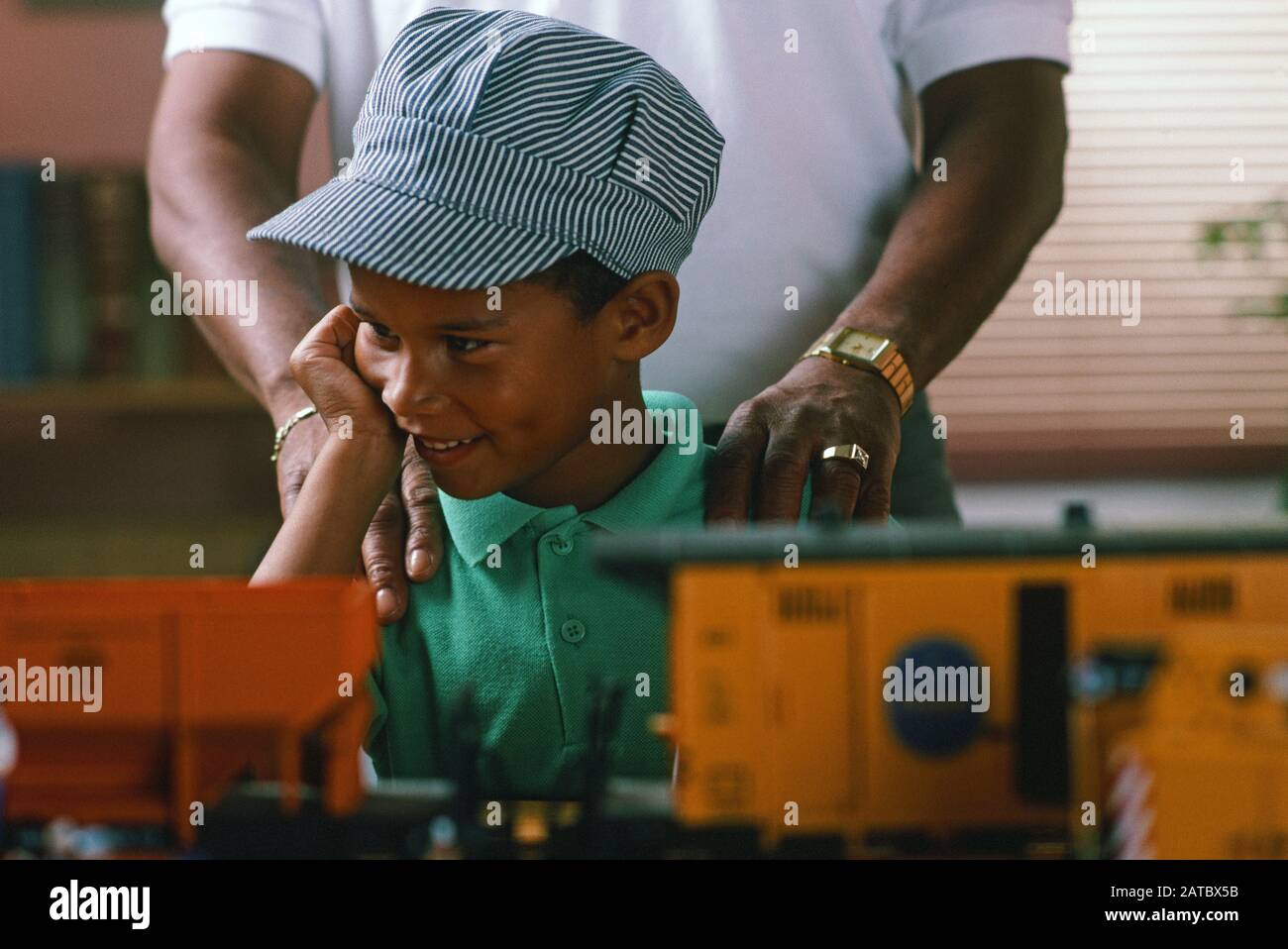 African-American Grandfather and grandson playing with a set of G gauge electric trains Stock Photo